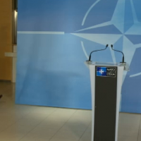 La sortie de la délégation russe, derrière le panneau où va s'exprimer le secrétaire général de l'OTAN (crédit : B2/Otan Tv)